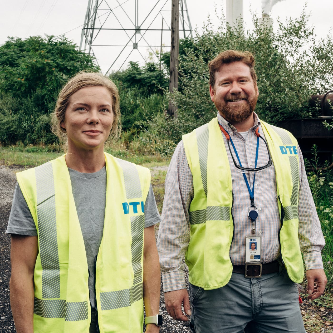 Two DTE crews with bright logo vest at a field.