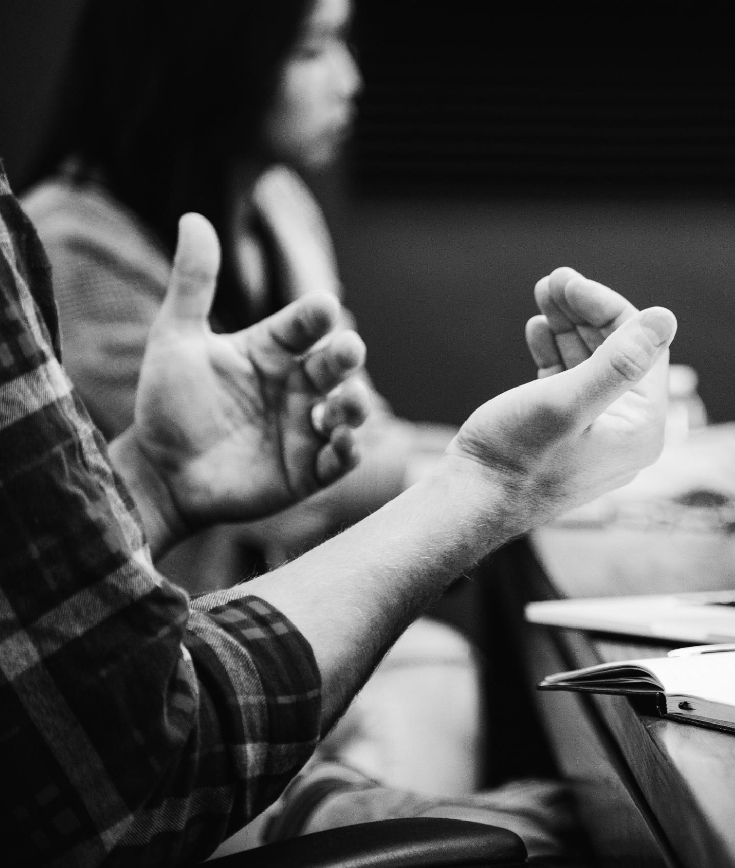 Close up of active hands in a conversation in a classroom.