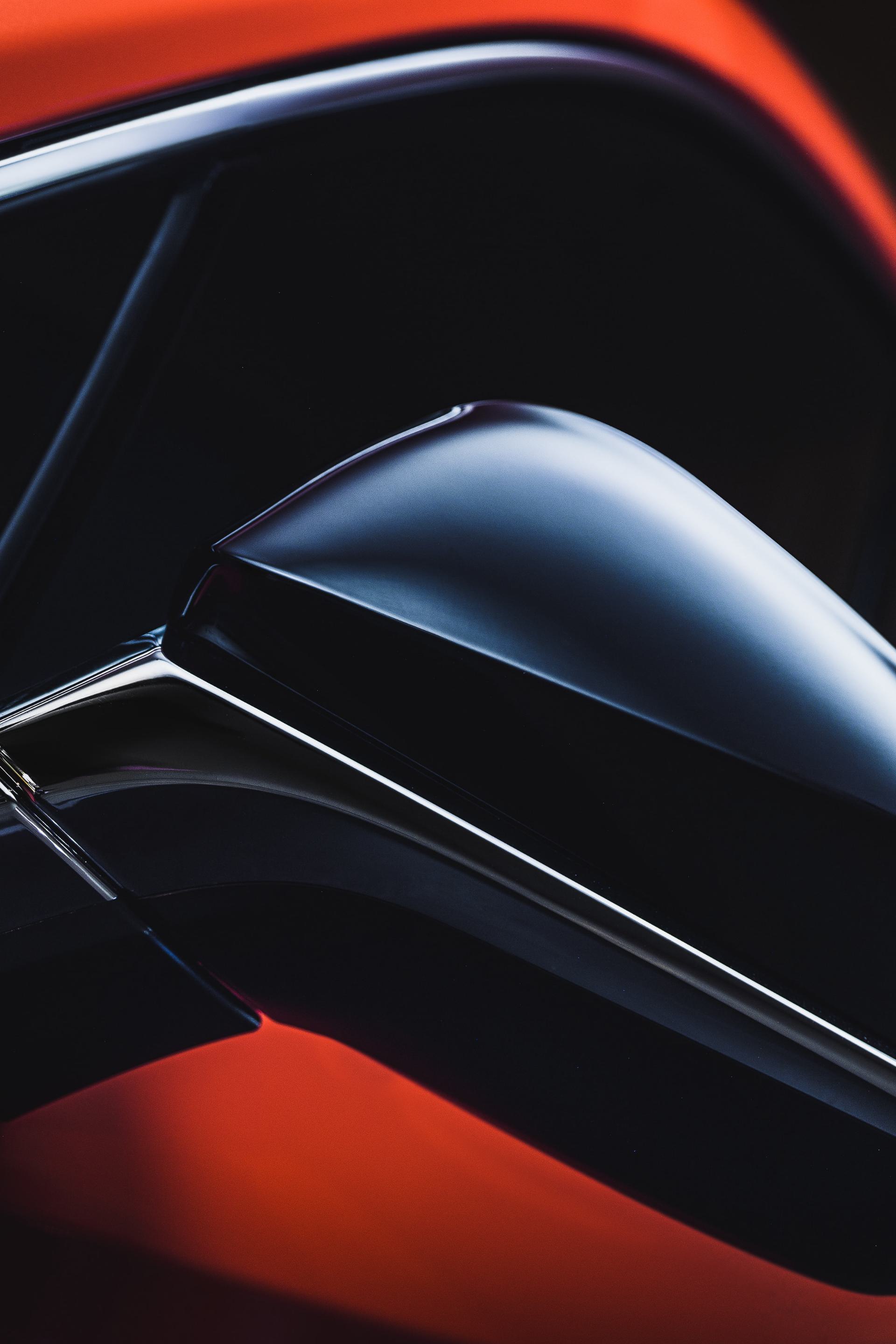 A closeup view of the driver side mirror of a red car.