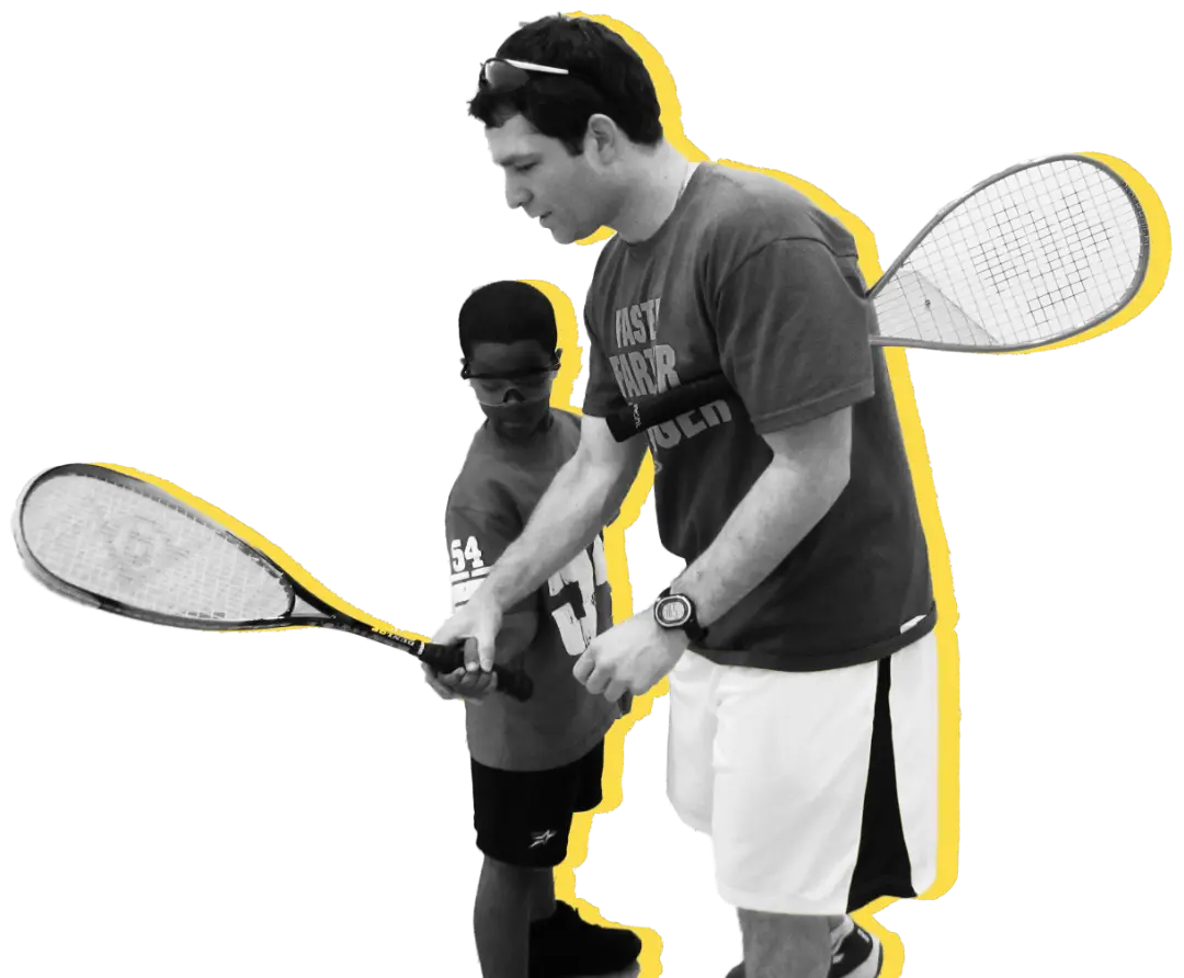 A coach demonstrating a forehand swing to a young kid.